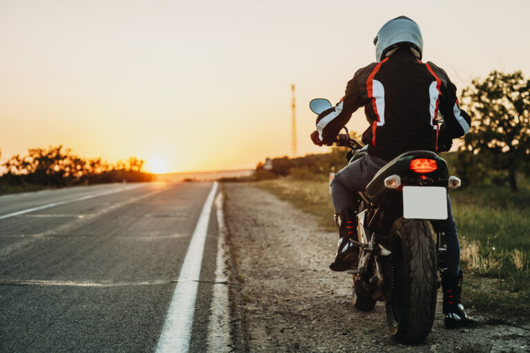 Motorcycle rider stopped on side of highway
