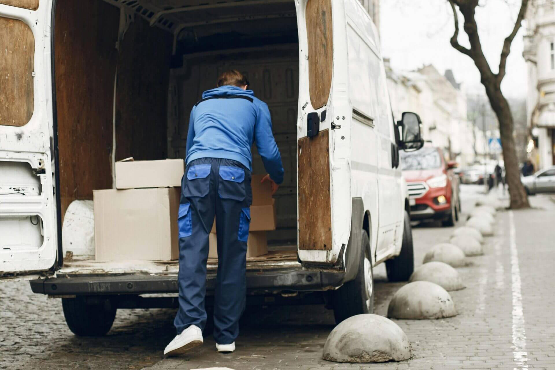 Delivery vehicle with worker removing boxes from back