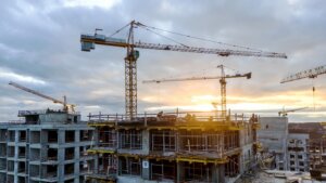 Two tall construction cranes over work site