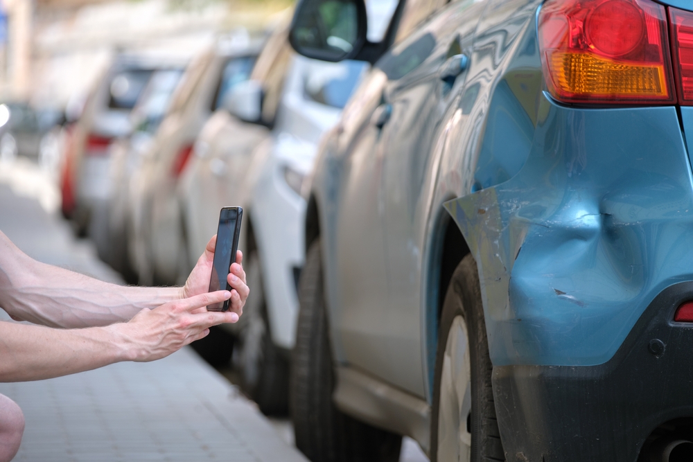 Driver records evidence of damage after car accident