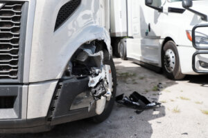 Damage to front wheel and fender of semi truck after an accident